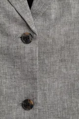 Blazer gris jaspeado de corte oversize, con botonadura sencilla de un botón, solapas de muesca, hombreras y forro interior negro.