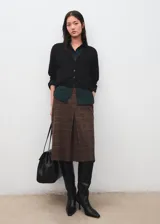 Cardigan de punto fino color negro, de corte recto, con escote en V, mangas largas y cierre frontal de botones.