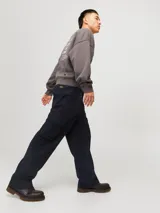Pantalón cargo de corte amplio y tiro medio, confeccionado en sarga de algodón resistente. Presenta bolsillos laterales tipo cargo, bolsillos delanteros y traseros, cierre con cremallera y diseño de pierna ancha.