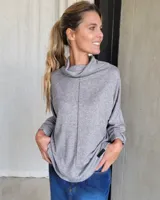 Polera gris oversize de lanilla, con cuello alto vuelto y costura central vertical en el frente. Manga larga y corte amplio.