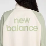 Campera deportiva New Balance, modelo WJ53517GAS, con diseño de bloques de color. Cuerpo principal color crema y mangas y hombros en verde salvia. Cierre frontal, cuello alto y puños y cintura elásticos. Logo NB bordado en el pecho.
