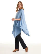 Poncho tejido de punto con diseño asimétrico y aberturas laterales para los brazos.