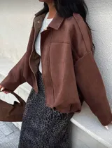 Campera tipo bomber de gamuza en color marrón, con cuello clásico, mangas largas amplias y ruedo elástico que genera un efecto fruncido.