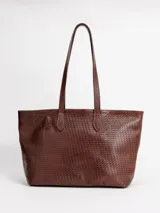 Bolso shopper grande de cuero marrón con diseño trenzado y dos asas de hombro. Cuenta con cierre superior y forro interior.