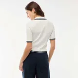 Sweater de punto canalé en color blanco, con cuello tipo polo, cierre frontal de tres botones dorados y detalles de rayas en contraste en el cuello, mangas y ruedo.