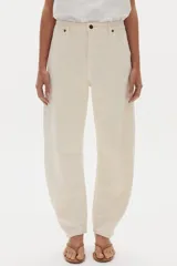 Pantalón de jean color blanco marfil, con tiro medio, corte barrel relajado y bolsillos frontales y traseros.