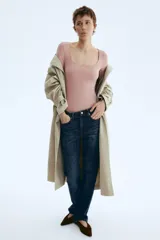Body de manga larga confeccionado en punto elástico color rosado, con diseño colaless, escote cuadrado y cierre con botones a presión en la parte inferior.