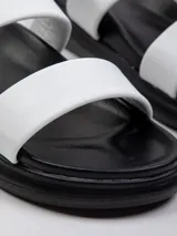 Sandalia baja negra de símil cuero con doble tira ancha sobre la capellada y plataforma de 2 cm.