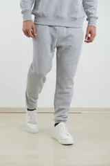 Pantalón jogging de tejido circular con cintura elástica y cordón ajustable. Presenta puños elastizados en el ruedo y bolsillo lateral tipo parche.