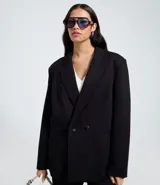 Blazer negro de mujer, modelo largo, con solapas y cierre cruzado de doble botonadura.