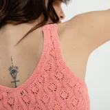 Top tejido color verde esmeralda, con cuello en V y sin mangas.