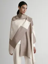 Poncho tipo spolverino bicolor, beige y visón, con diseño geométrico.