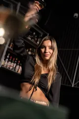 Top corto negro con escote en V, mangas largas y lazo ajustable en el centro.