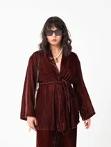 Kimono de terciopelo color bordó, con mangas largas amplias, abertura frontal y lazo ajustable en la cintura.