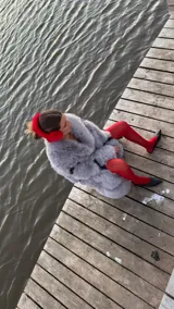 Chaqueta gris de piel sintética con cuello solapa y cierre cruzado con botones a presión.