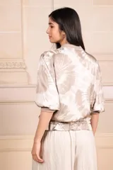 Bomber de seda con estampado batik, cuello redondo, cierre frontal con cremallera, mangas cortas y puños elásticos.