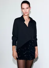 Short de tiro alto confeccionado en tejido de terciopelo con aplicación de lentejuelas brillantes. Presenta un diseño corto con cierre de cremallera lateral.
