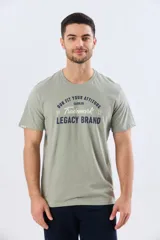 Remera verde pistacho de manga corta y cuello redondo, con diseño gráfico estampado en el frente con inscripciones y tipografías en tonos oscuros y blancos.