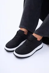 Championes urbanos de diseño minimalista, color negro con suela blanca y base negra. Presentan cordones al tono y puntera perforada.