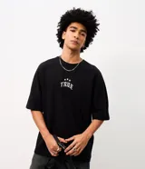 Remera oversized de algodón negro, con cuello redondo y mangas cortas. Presenta un gran estampado en la espalda con la inscripción "True Star" en tipografía gótica y detalles de estrellas.