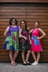 Vestido corto magenta con estampado floral en tonos rosados y celestes, sin mangas y corte evasé.