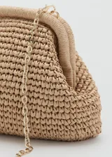 Bolso tipo clutch de tamaño pequeño y diseño rígido, confeccionado en tejido de fibra natural de papel con textura trenzada. Cuenta con cierre superior de marco metálico a presión y forro interior de poliéster.