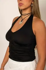 Top halter blanco con fruncidos en el centro y escote pronunciado.