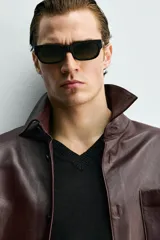 Sobrecamisa relaxed fit de cuero color marrón oscuro, con cuello solapa, manga larga con puño abotonado, bolsillo de parche en el pecho y cierre frontal de botonadura.
