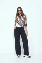 Remera de manga larga con tejido tipo mesh, diseño de rayas verticales en tonos marrones y blancos, cuello polo negro y puños tejidos con detalle de rayas.