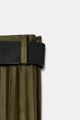 Falda midi de tiro alto en tejido plisado color verde oliva. Presenta un cinturón negro a contraste con hebilla metálica dorada y cierre lateral con cremallera oculta.