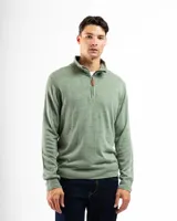 Buzo de tejido de punto color verde claro jaspeado, con cuello alto y cierre frontal parcial con tirador de cuero. Presenta puños y ruedo acanalados.