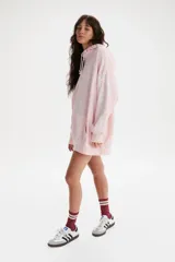 Buzo hoodie rosa con cordones blancos y bolsillo tipo canguro. Estampado frontal pequeño con el logo de Levi's en blanco y estampado grande en la manga con la frase "Endless Dreams" en letras cursivas blancas.