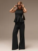 Conjunto de dos piezas color negro compuesto por un top sin mangas con diseño peplum y un pantalón de corte recto y tiro alto.