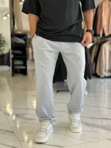 Pantalón de jogging gris melange, con diseño oversize y corte recto, ideal para un estilo urbano y cómodo.