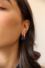Aros dorados con dije circular de piedra natural negra.