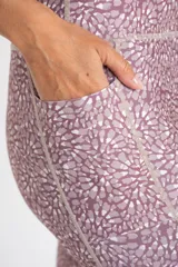 Legging deportivo de tiro alto con estampado botánico abstracto en tonos rosados y marrones, confeccionado en tejido elástico de secado rápido.