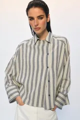 Camisa de corte oversize confeccionada en mezcla de viscosa, con estampado de rayas verticales. Presenta cuello solapa, cierre frontal con botones y mangas largas con puños amplios.