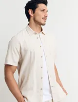Camisa sport de manga corta, confeccionada en una mezcla de lino y algodón. Presenta cuello clásico, cierre frontal con botones de coco y un bolsillo en el pecho.