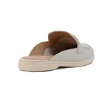 Zueco Comfortflex de color beige con textura sutil, detalle de vincha metálica dorada en el empeine, diseño destalonado y suela baja.