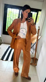 Pantalón sastrero de corte recto y tiro medio, confeccionado en una mezcla de lino con acabado metalizado de lurex, que le otorga una textura brillante y una caída ligera.