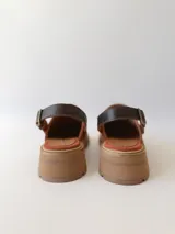 Zueco de cuero color ladrillo con correa trasera ajustable color marrón oscuro y suela track color marrón claro.