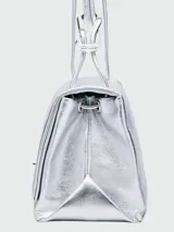 Cartera tipo shoulder bag de Marc Jacobs en color plateado metalizado, con diseño estructurado, solapa frontal y cierre metálico giratorio.