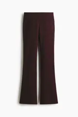 Pantalón ajustado de punto fino en color bordó, de tiro alto con elástico revestido en la cintura y diseño de piernas acampanadas.