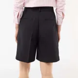 Bermuda de tiro alto color negro, con diseño de pinzas en el frente, corte recto y largo por encima de las rodillas.