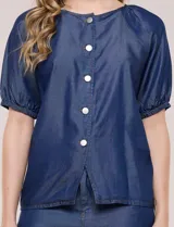 Blusa de calce relajado de lyocell en tono azul denim, con cuello a la base y cierre frontal de botones metálicos. Tiene mangas cortas abullonadas con puños elásticos.