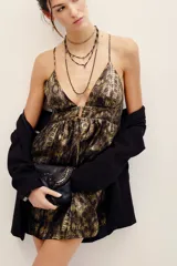 Vestido corto de poliéster con estampado animal print tipo piel de serpiente en tonos marrones y dorados. Presenta escote en V pronunciado, tirantes finos y detalle de argolla metálica en el centro del busto.