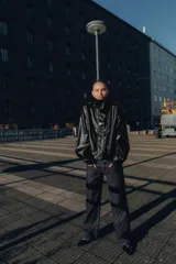 Chaqueta de efecto piel con cuello subido, manga larga con puños y bajo elástico. Presenta cierre frontal con cremallera y botones a presión ocultos, además de bolsillos laterales y forro interior.