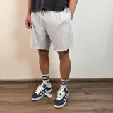 Short de algodón gris melange con cintura elástica y cordón de ajuste, de corte holgado y ruedo sin costura.