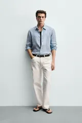 Camisa celeste de lino de corte regular fit, con cuello abotonado, manga larga y cierre frontal de botonadura.