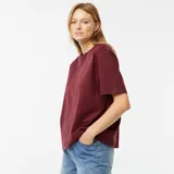 Remera de cuello redondo color borgoña, corte holgado y mangas cortas con dobladillo.